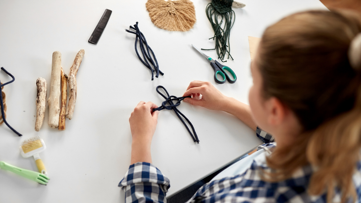 Young girl using strong to create macrame